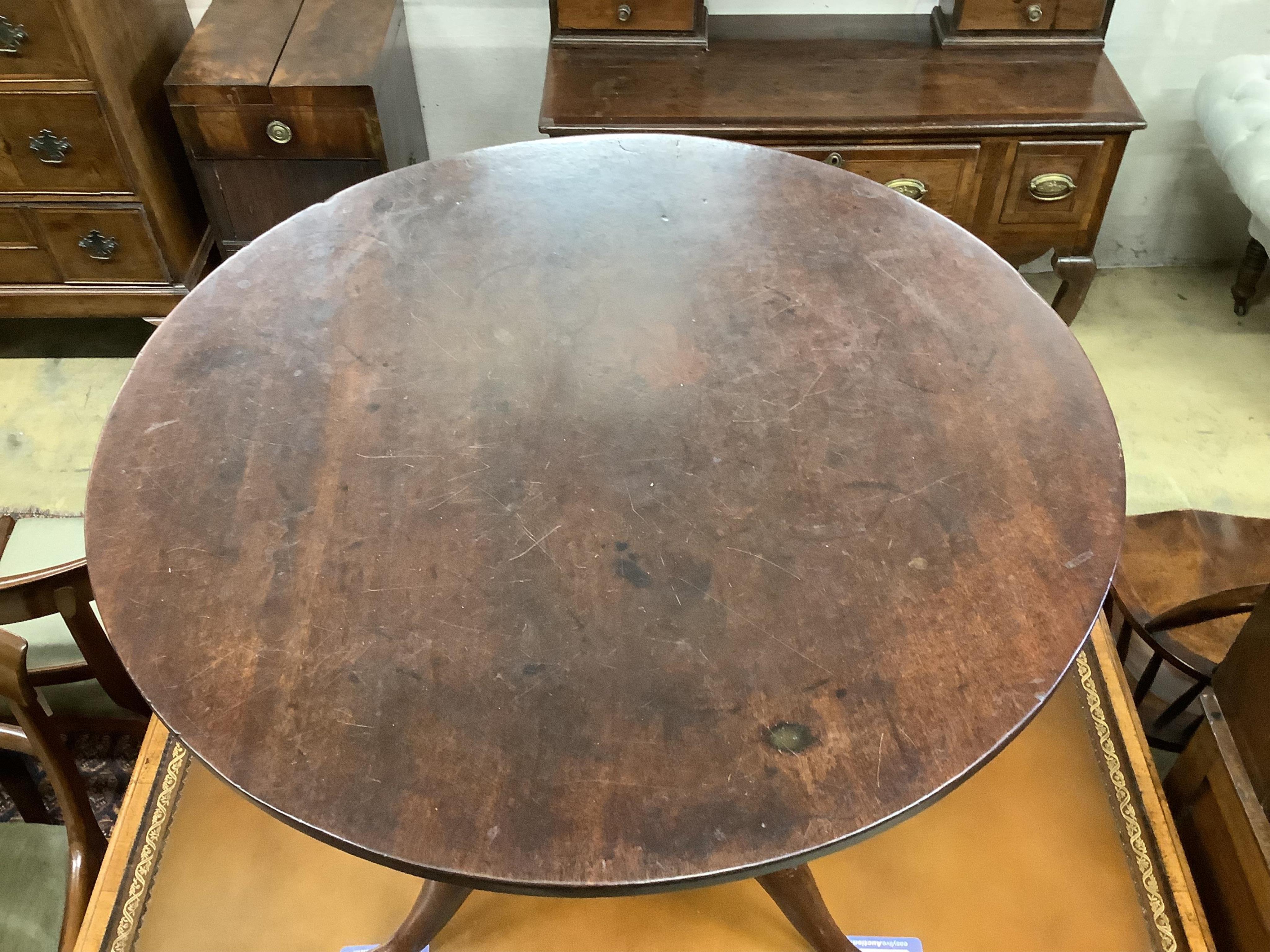 A George III circular mahogany tilt top bird cage tripod tea table, diameter 69cm, height 69cm. Condition - fair